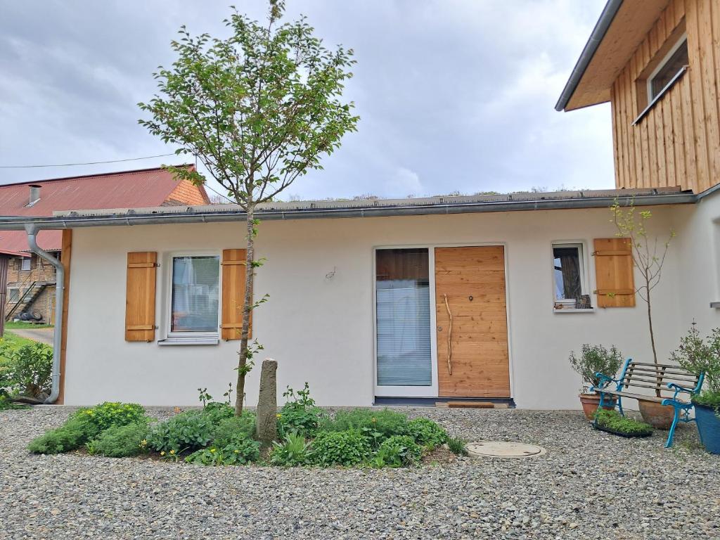 a house with a tree in front of it at ländlicher öko-flair im Strohhaus in Frickingen
