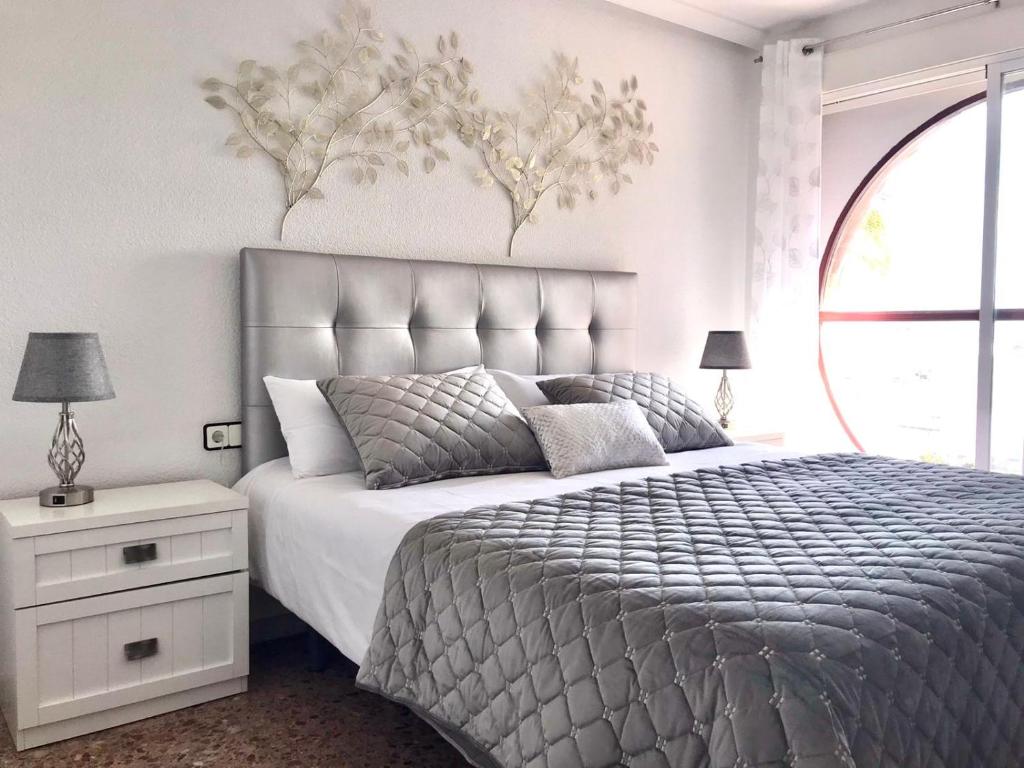 a bedroom with a large bed and a large window at Mar y Vistas Puerto Santa Pola in Santa Pola