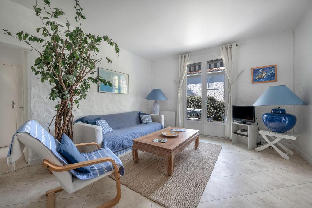 un salon avec un canapé bleu et une table dans l'établissement 20m de la mer - Terrasse - Appartement pour 6, à Pornic