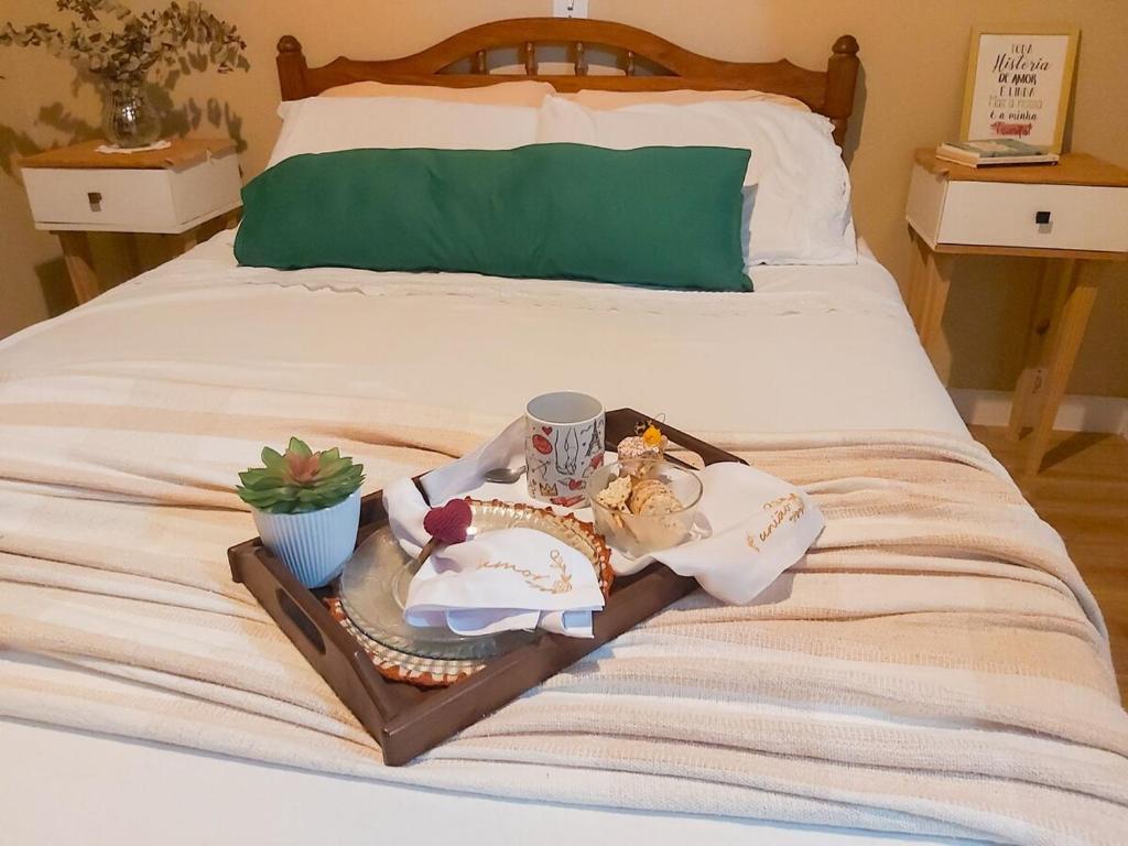 a bed with a tray with food and drinks on it at House in the Serra de Teresópolis - Chamego da Serra in Teresópolis