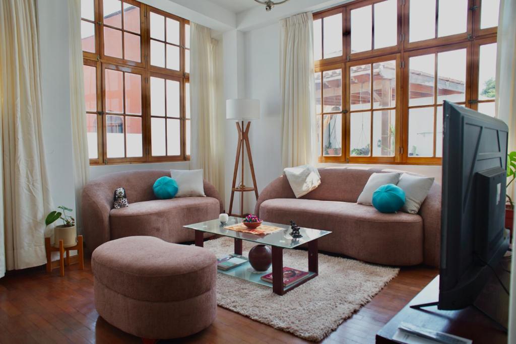 a living room with two couches and a tv at Mirandoelmar Apartment - SOL in Lima
