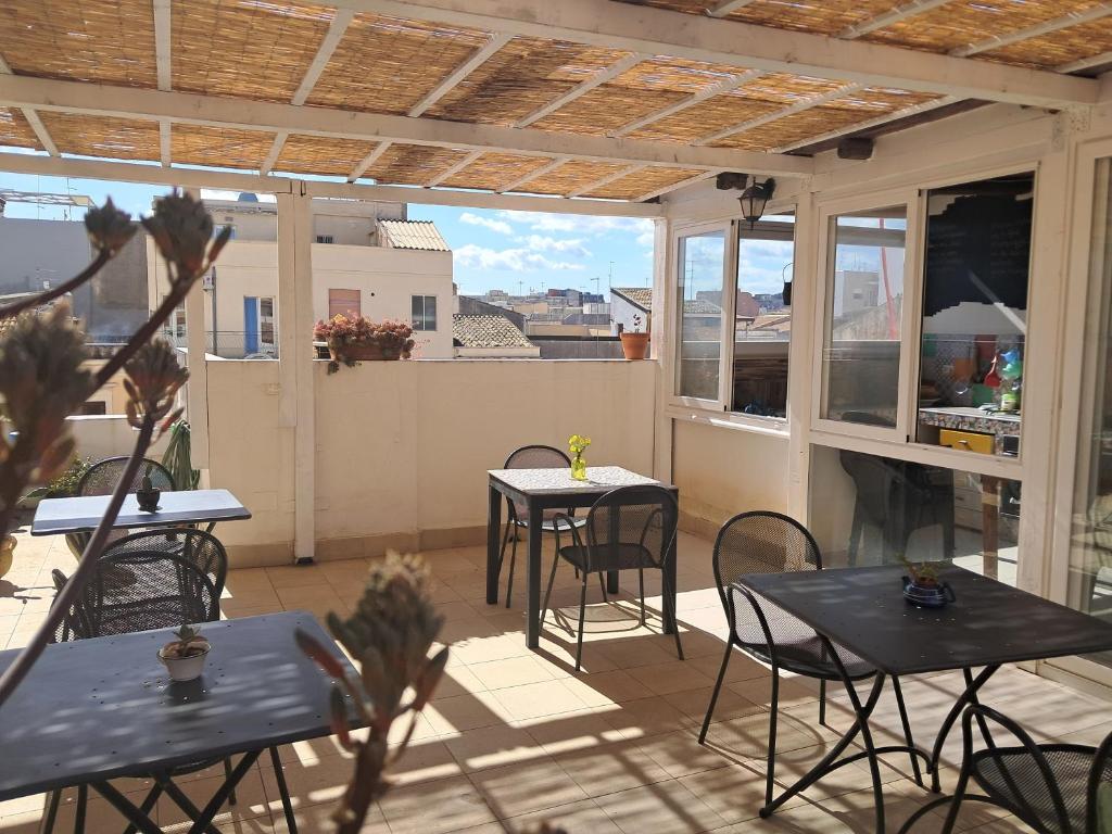 a patio with tables and chairs on a balcony at La casa di Aneupe in Syracuse