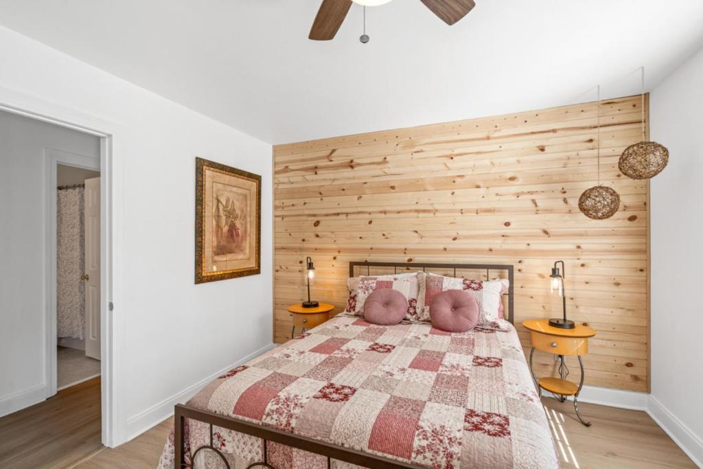 ein Schlafzimmer mit einem Bett mit einer Holzwand in der Unterkunft Sunset Serenity!!-Tropical Waterfront Oasis-Huge Private Patio-10Min to KingSt & Beaches in Charleston