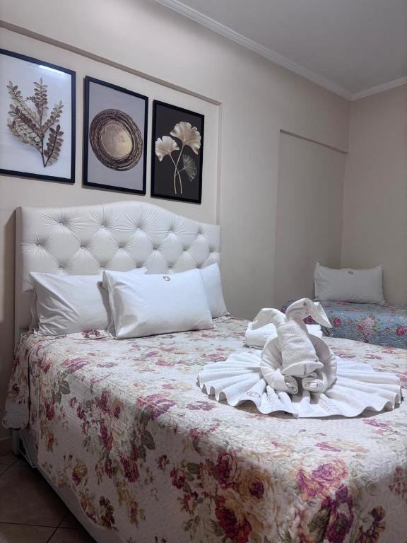 a stuffed animal sitting on top of a bed at Flat Cavalinho Branco 119 in Águas de Lindoia
