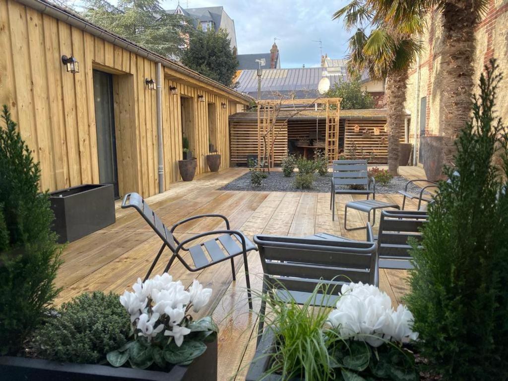 d'une terrasse avec des chaises et une table fleurie. dans l'établissement Villa Les Planches proche Place Morny, à Deauville