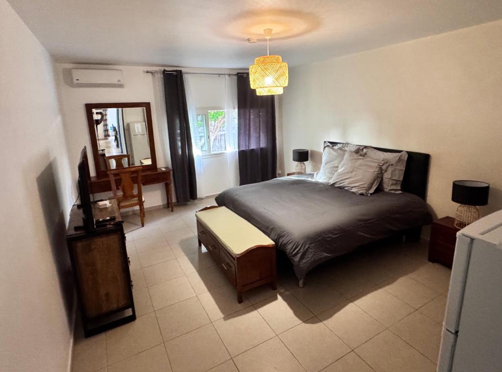 a bedroom with a bed and a table and a mirror at Villa Rose-May in Saint-Pierre