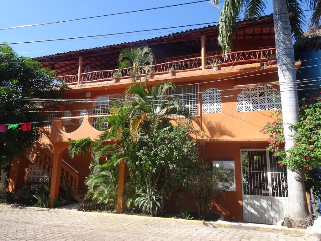 ein orangefarbenes Gebäude mit einem Balkon darauf in der Unterkunft Beautiful Casita at La Madera Beach, Zihuantanejo in Zihuatanejo