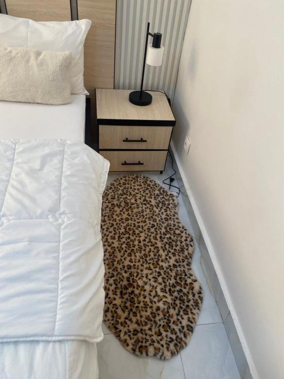 a bed with a leopard rug on the floor in a bedroom at La gloire House in Dakar