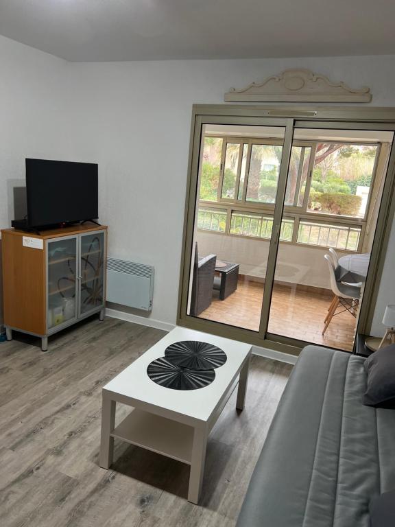 un salon avec un canapé et une table dans l'établissement Charmant studio calme bord de mer Wifi-NESPRESSO-DRAPS-LINGE DE BAIN-MENAGE inclus, à Saint-Mandrier-sur-Mer