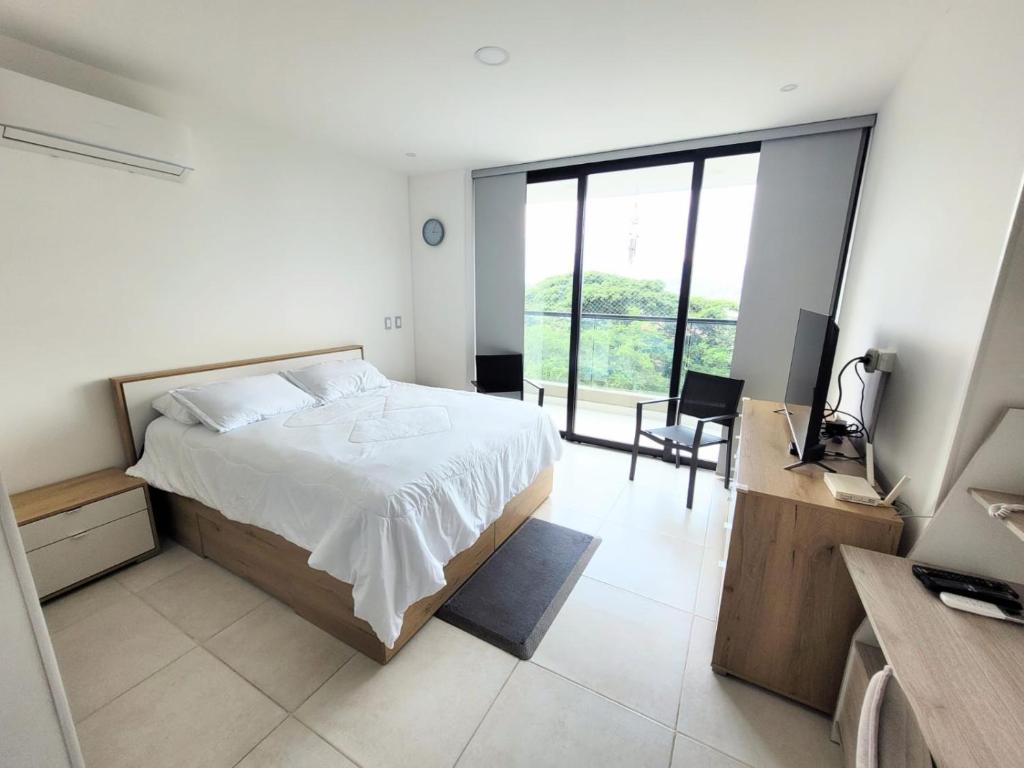 a bedroom with a bed and a desk and a television at Cali Piso 4-04 Pance Luxury Apartamento Exclusivo Sector in Cali