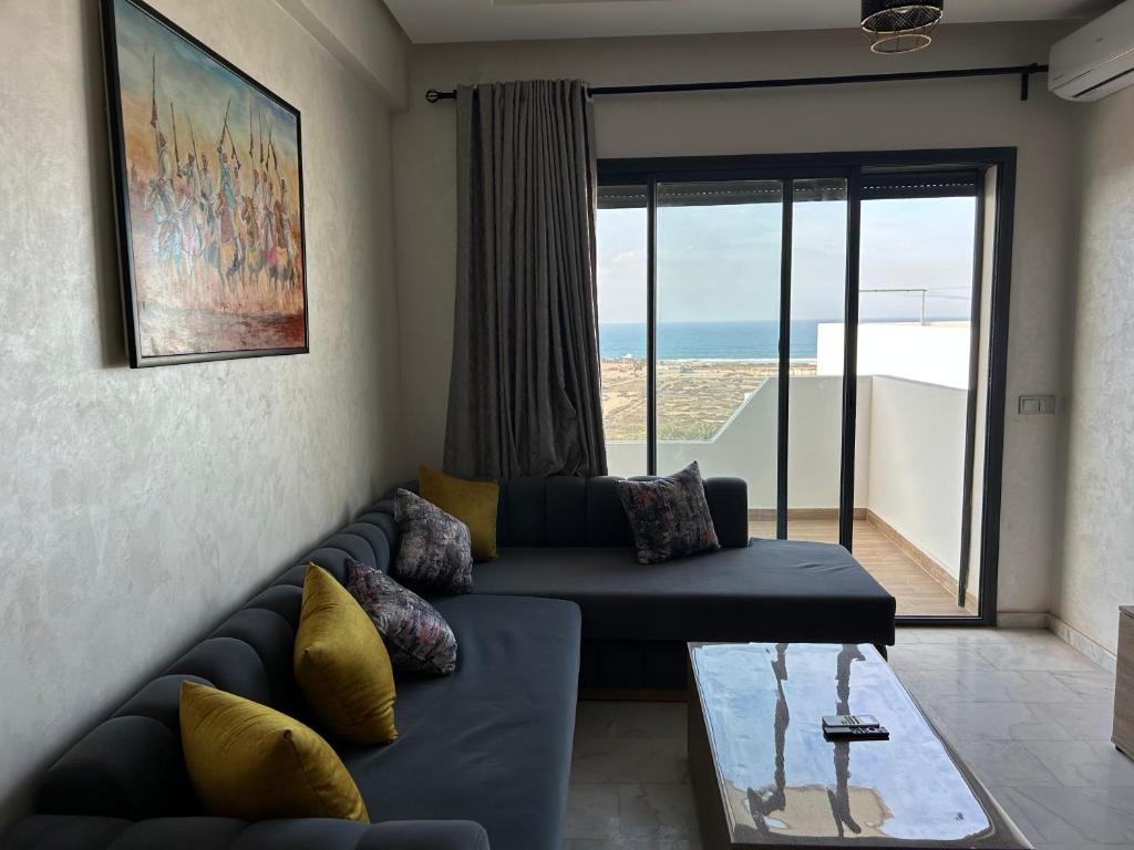 a living room with a couch and a glass table at Ocean park zenata in Aïn Harrouda