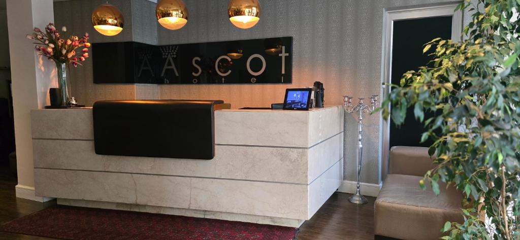 a lobby with a reception desk with a tv on it at Ascot Hotel in Johannesburg