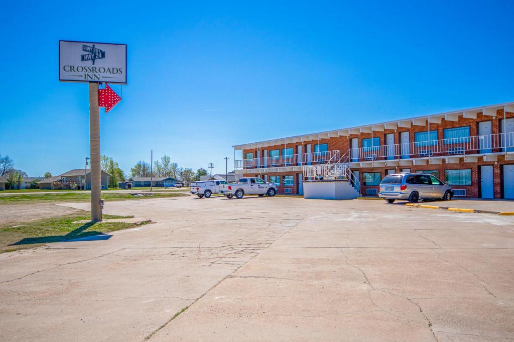 a sign in a parking lot in front of a building at OYO Crossroads Inn in Osborne