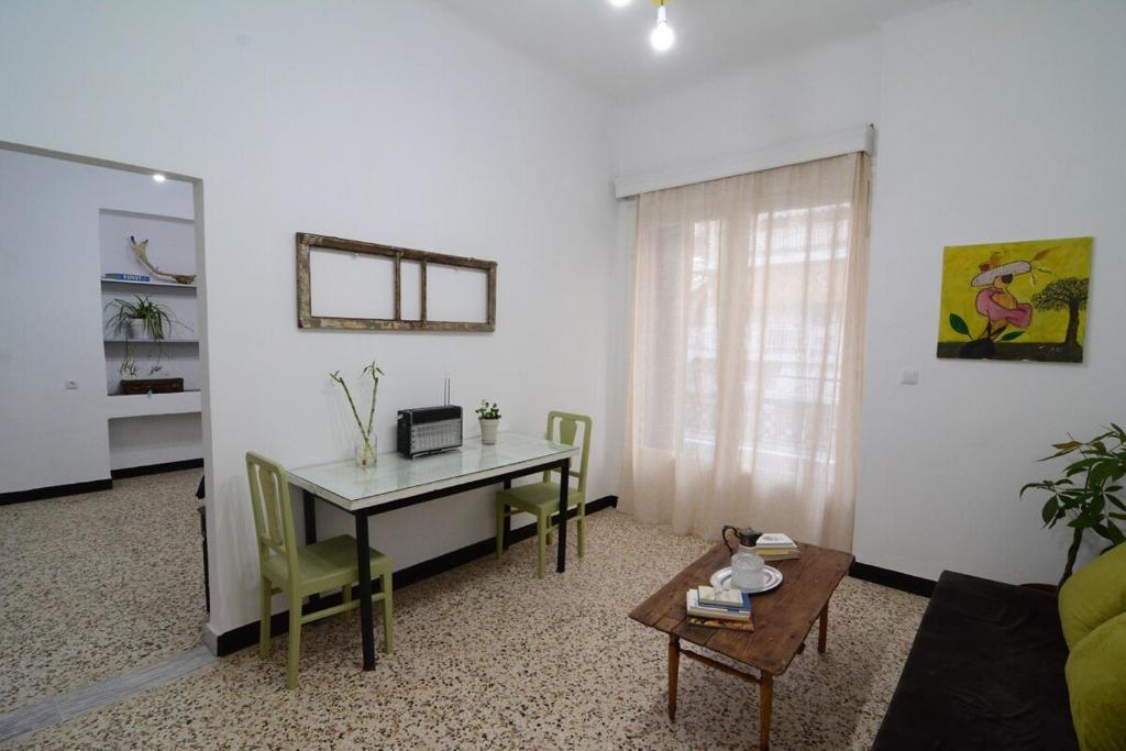 a living room with a desk and a table with chairs at The SPiTi Project 33 in Kavala