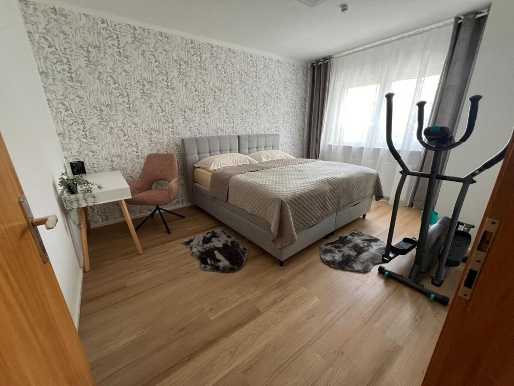 a bedroom with a bed and a desk and a window at Ferienwohnung Ferlach TOP1 in Ferlach