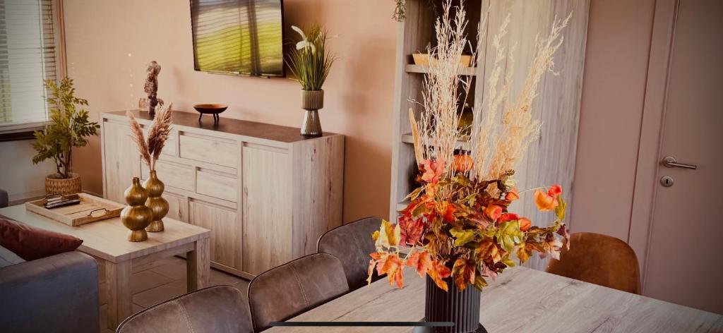 a living room with a table with a vase of flowers at Duinengolf in Middelkerke