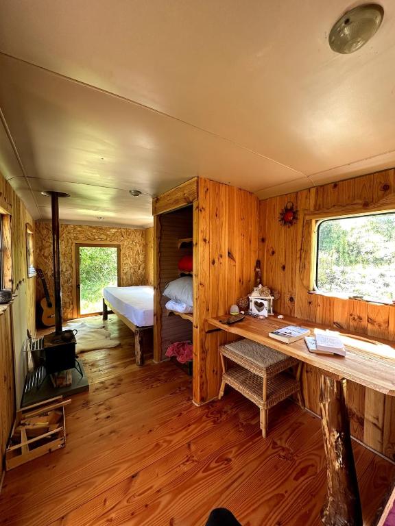 une chambre avec un lit et un bureau dans une pièce dans l'établissement Bus vintage pour retraite en solo à Bugarach, à Bugarach