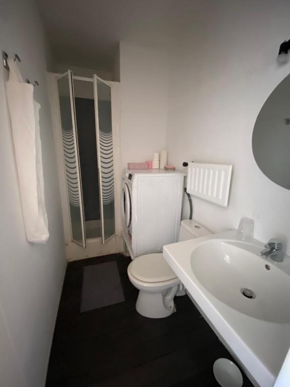 une salle de bain blanche avec des toilettes et un lavabo dans l'établissement Appartement dans résidence France, à La Celle-sous-Gouzon