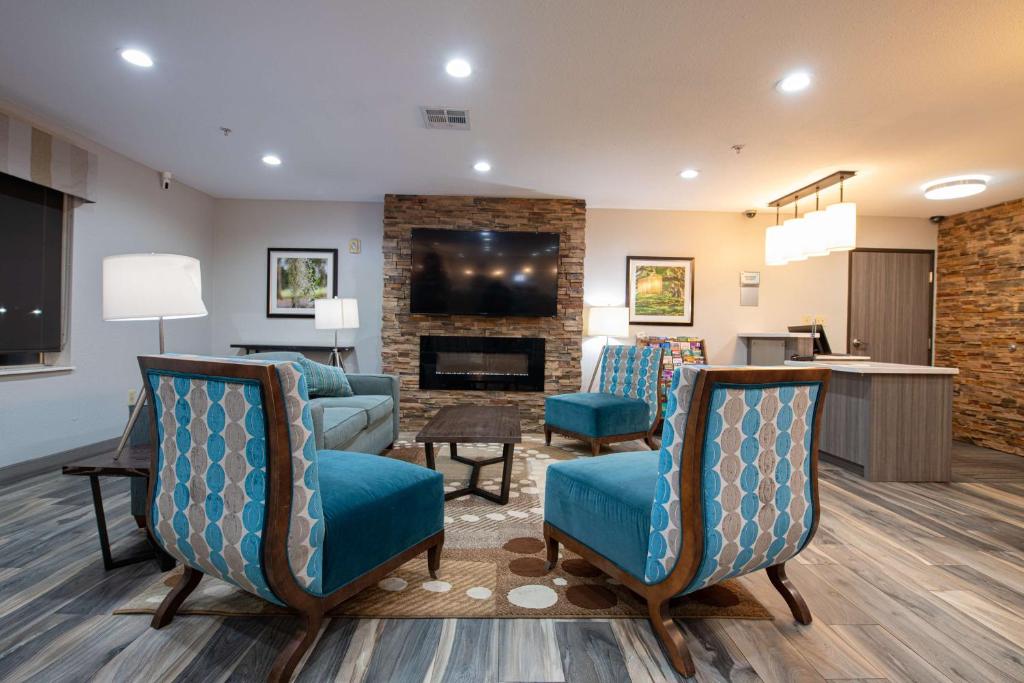 a living room with blue chairs and a fireplace at Best Western Lafayette Inn in Lafayette