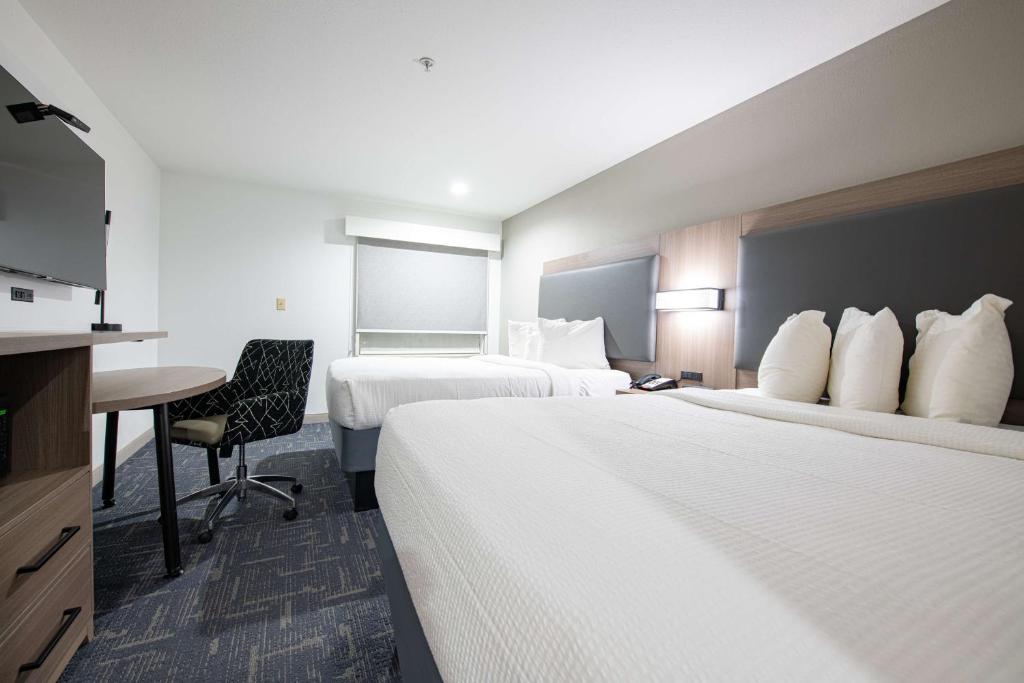 a hotel room with two beds and a desk at Best Western Lafayette Inn in Lafayette