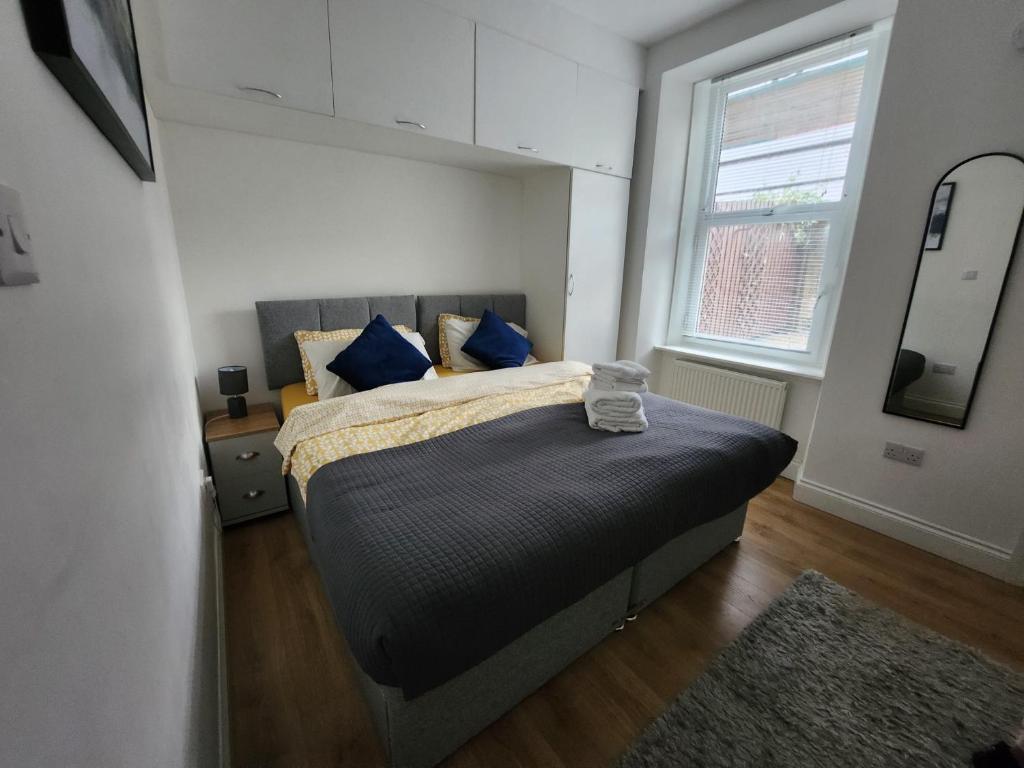 a bedroom with a bed with blue pillows and a mirror at Luxury 1-Bedroom Apartment - Central Dundee in Dundee