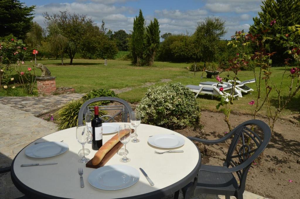 - une table blanche avec une bouteille de vin et des verres dans l'établissement Kastellbriant Cottage, à Saint-Aubin-des-Châteaux