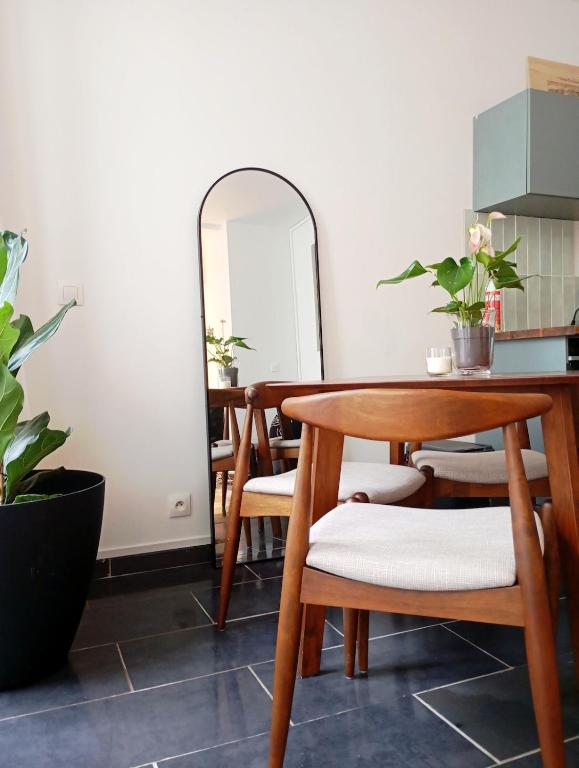 une salle à manger avec une table et un miroir dans l'établissement Cocon convivial a mommartre, à Paris