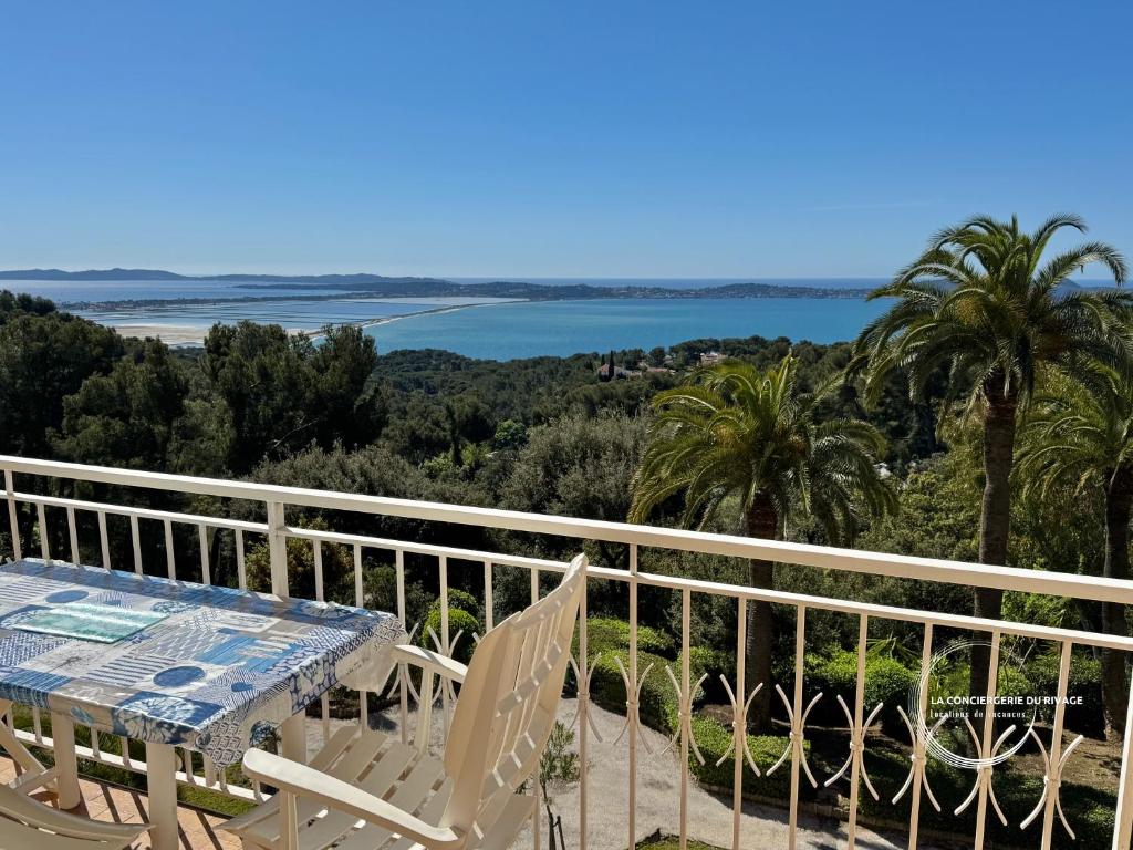 un balcon avec une table et des chaises et une vue sur l'océan dans l'établissement Le Mont des Oiseaux - Piscine - Vue panoramique, à Hyères