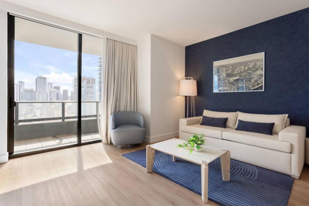 ein Wohnzimmer mit Couch und großem Fenster in der Unterkunft 2012 New Apt with Pool and Gym in front of Kaseya Center in Miami
