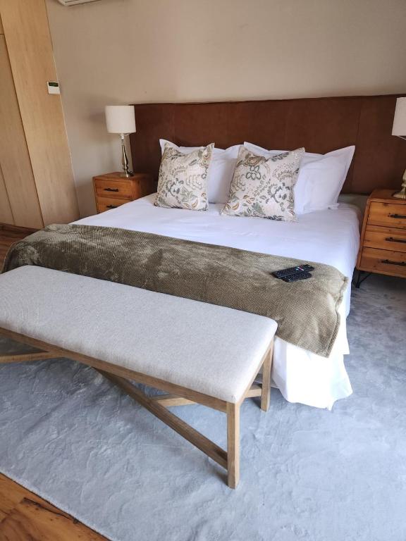 a large bed with a bench in a bedroom at The Hills at 1 Meeu in Newcastle