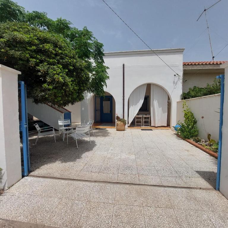 a courtyard with a white building and a tree at Villa Lucky in Punta Prosciutto