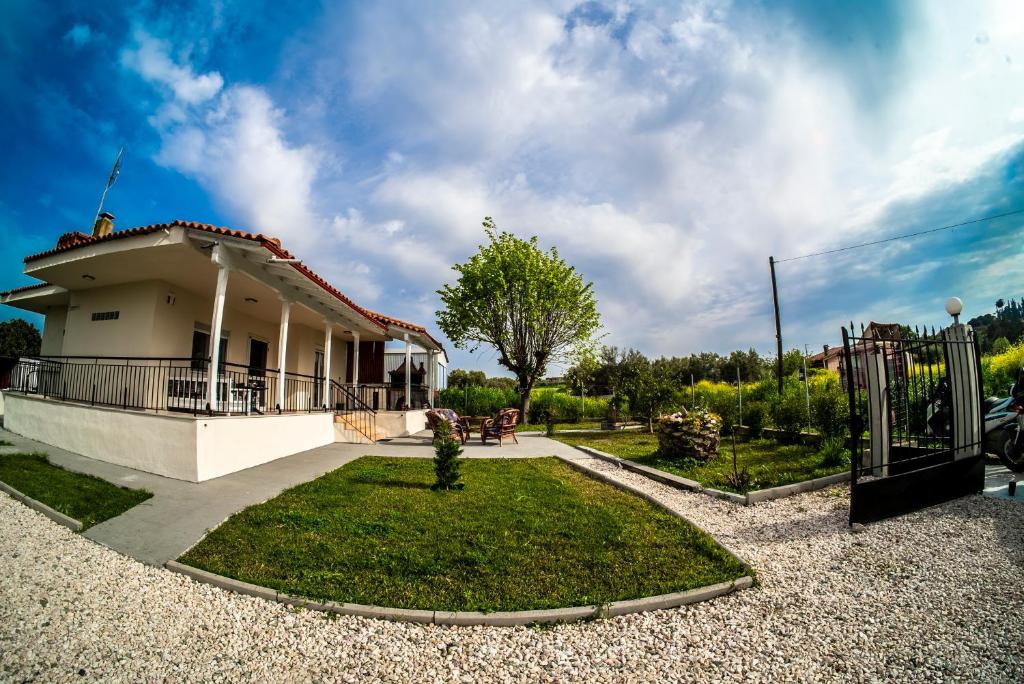 a house with a gate and a yard at Blackeye Hidden cottage in Nea Potidaea