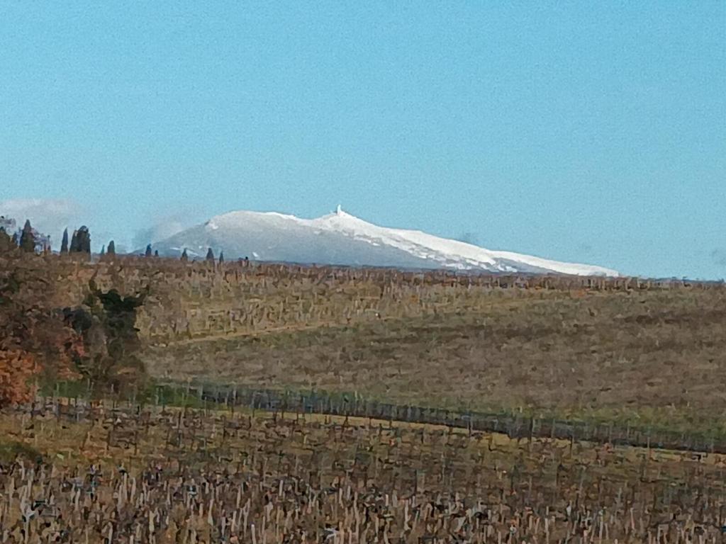 une montagne enneigée dans un champ avec une clôture dans l'établissement Maison en campagne, au Thor
