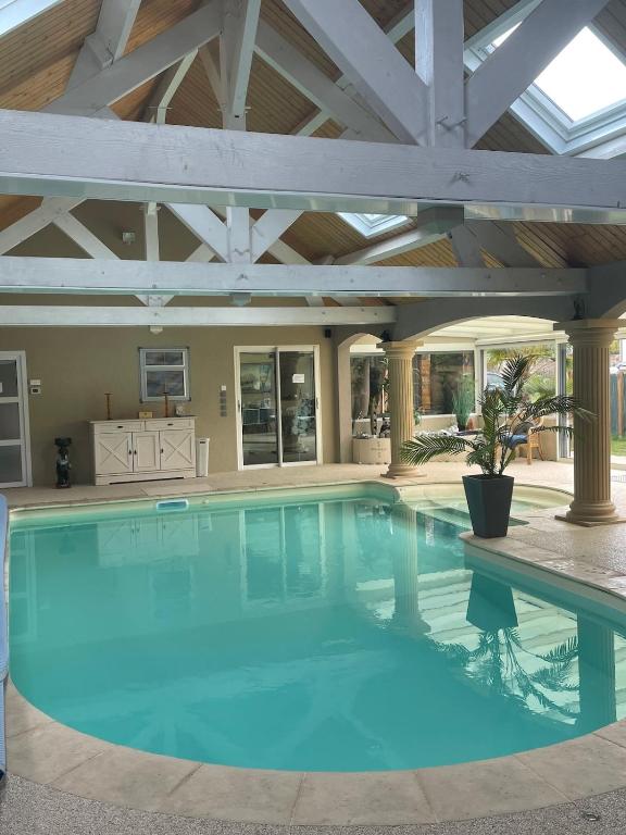 une grande piscine avec un plafond en bois dans l'établissement Osiris Espace Piscine couverte et Chauffée, à Mesves-sur-Loire