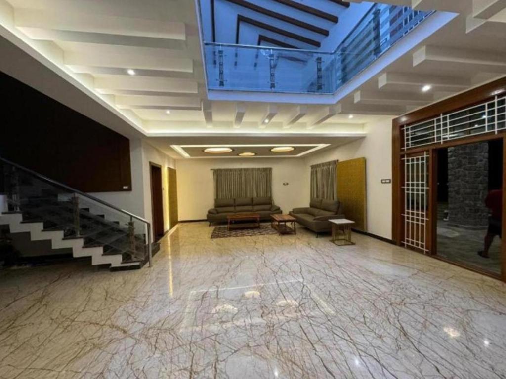 a large room with a couch and a tv in it at ST Kodai Heaven Stay in Kodaikānāl