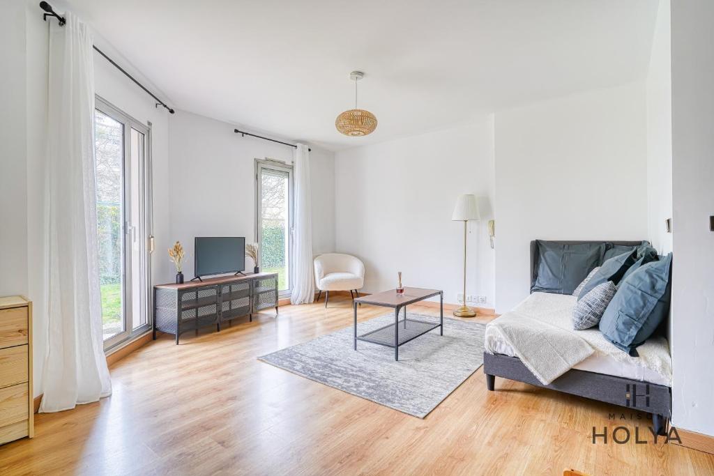 - un salon blanc avec un lit et une table dans l'établissement Le Calme aux portes de Paris - 400B, à Rueil-Malmaison