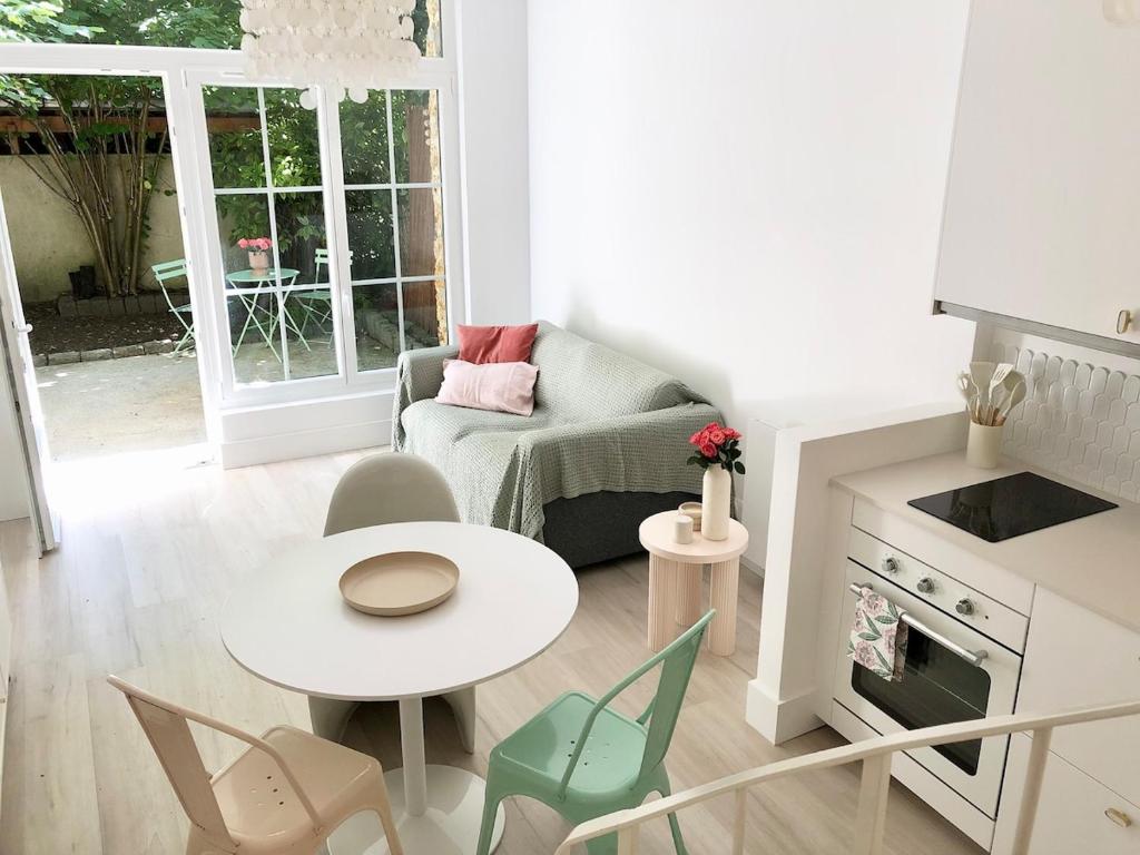 a small living room with a table and chairs at Villa Mini Romy with outdoor area in Parmain