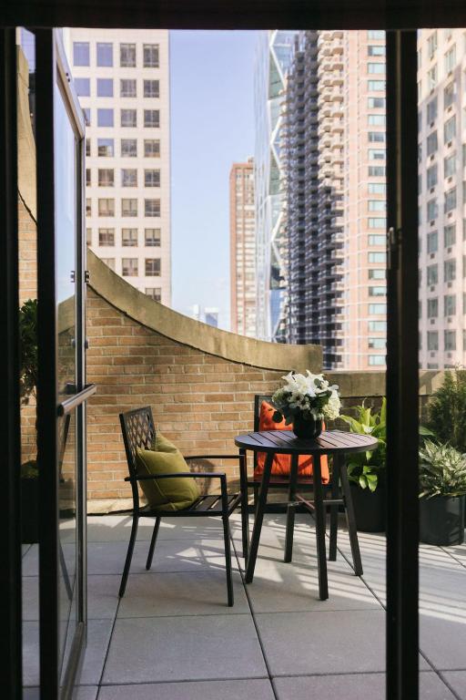 Una mesa y sillas en un balcón con vista a una ciudad. en The Manhattan Club, en Nueva York