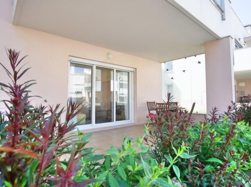 ein Haus mit Glastüren und Pflanzen in der Unterkunft Casa Aromas do Mar, Burgau in Burgau