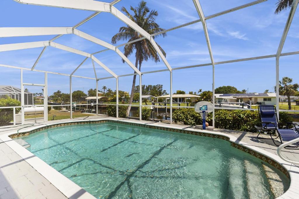 ein großer Pool mit Baldachin und Stühlen um ihn herum in der Unterkunft Tiffany Treasure in Cape Coral