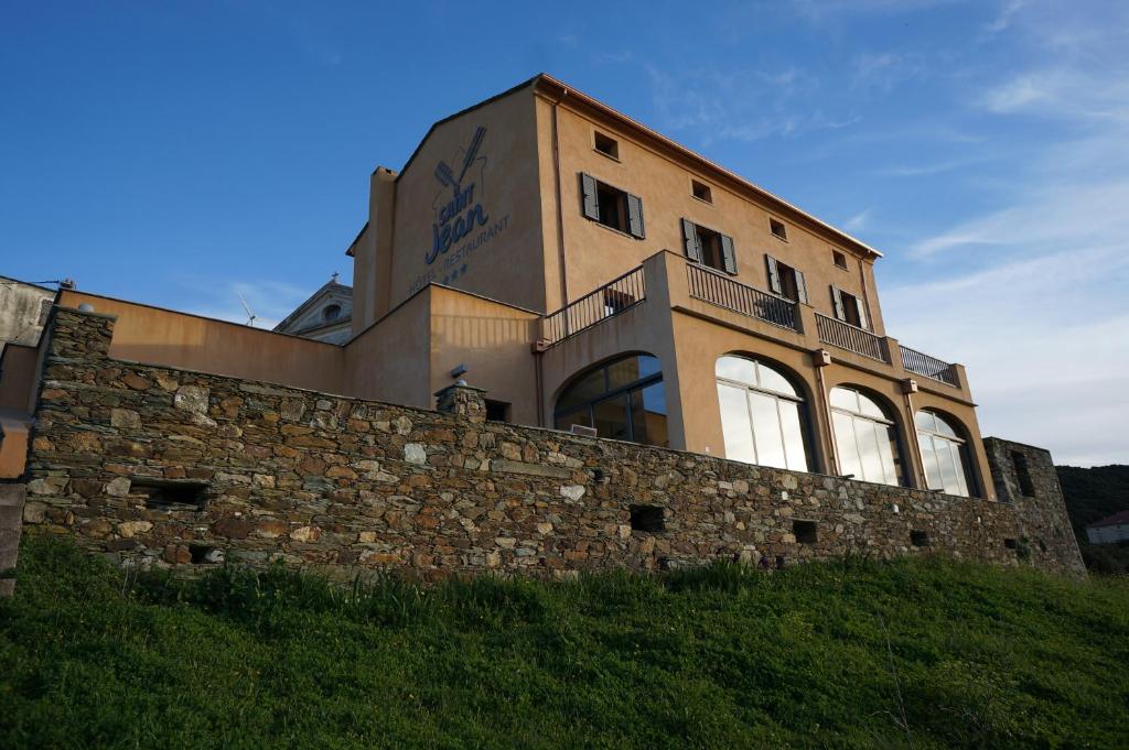 a building on top of a stone wall at Hotel Le Saint Jean in Ersa