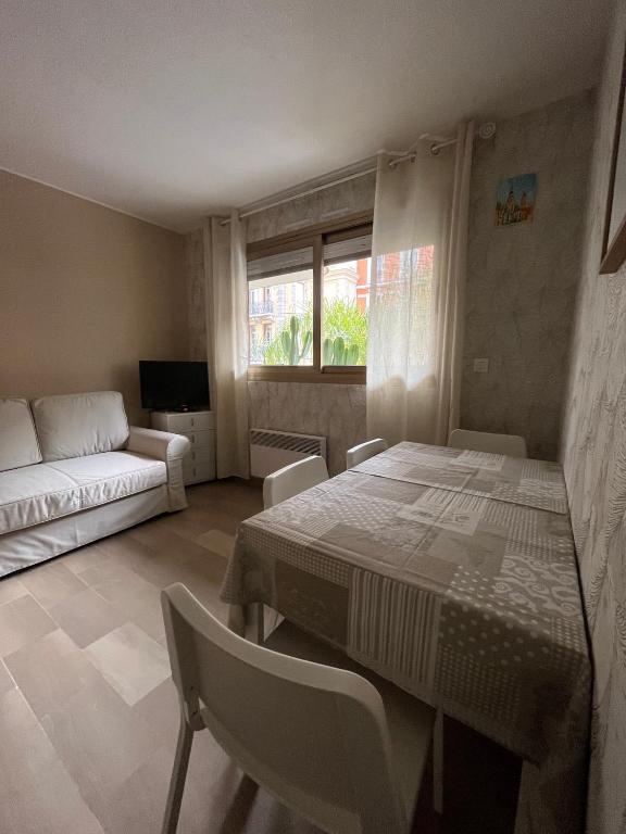 un salon avec une table et un canapé dans l'établissement Le GOLF studio proche mer, à Menton