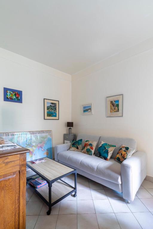 un salon avec un canapé et une table dans l'établissement Petite maison de ville avec cour privée & clim près Arènes MaisonCarréeConciergerie, à Nîmes