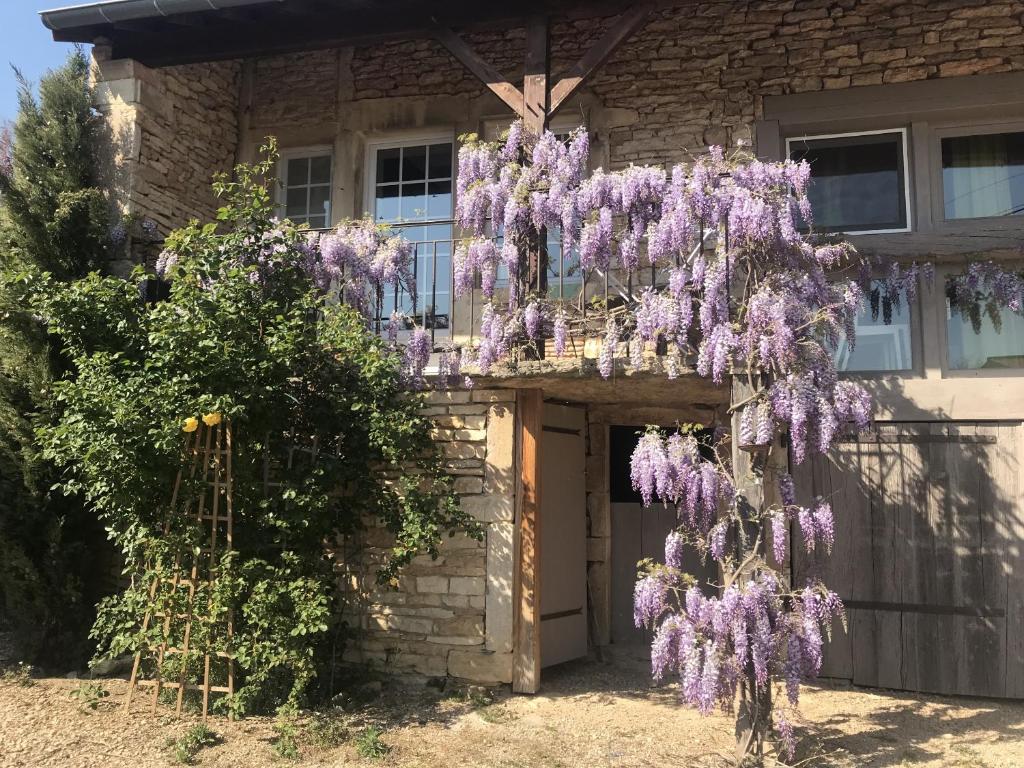 une couronne de fleurs violettes suspendue à un bâtiment dans l'établissement Gîtes L'Art d'une Pause, à Champagny-sous-Uxelles