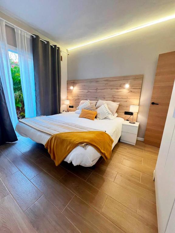 a bedroom with a large bed with a wooden headboard at Oasis del Puerto Spacious Premium Apartment in Puerto de la Cruz