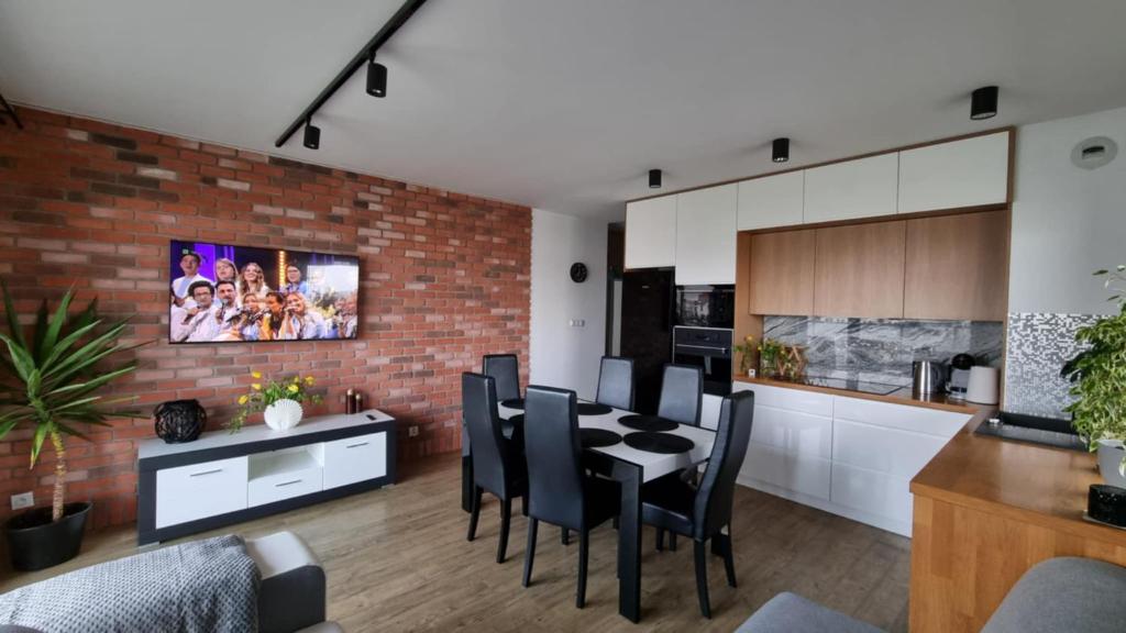 a kitchen and dining room with a brick wall at Apartament Bianco - Aquapark in Rumia
