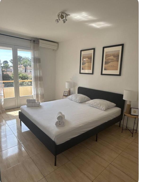 une chambre avec un grand lit avec des draps blancs dans l'établissement L'Etoile à deux pas de la mer, à Boulouris-sur-Mer