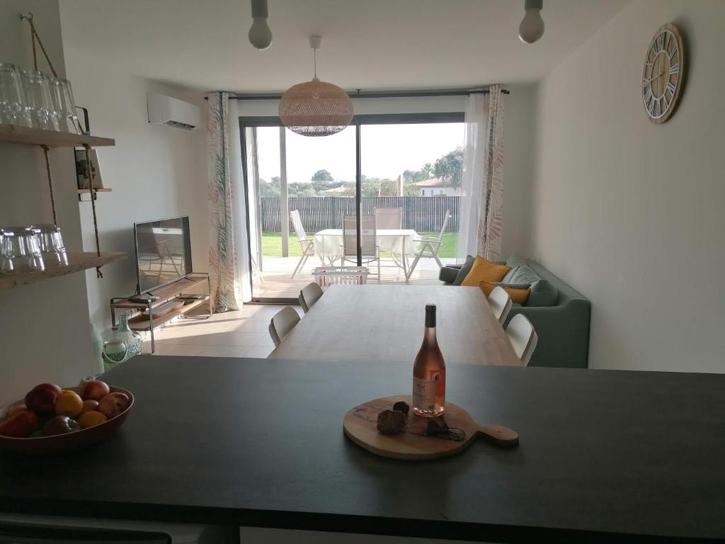 - une bouteille de vin sur une table dans le salon dans l'établissement Porticcio grand appartement 3 pièces, 5 minutes de la plage, à Porticcio