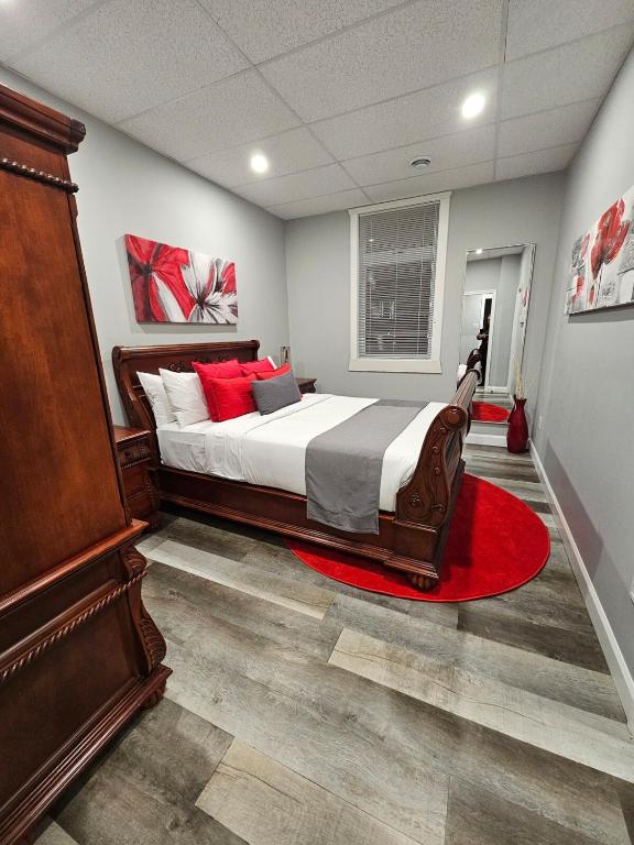 a bedroom with a large bed and a red rug at Cozy Apartment #8-B in Gatineau