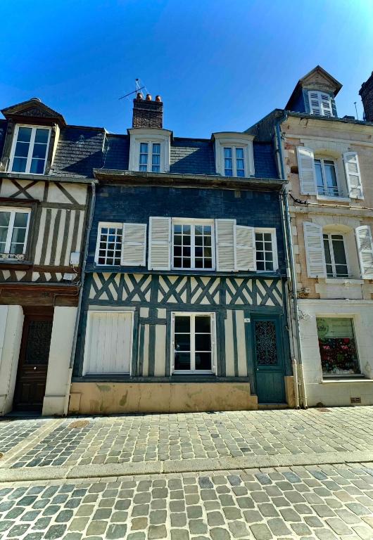 un vieux bâtiment avec un bâtiment bleu et blanc dans l'établissement Appartement mignon en Hypercentre Honfleur - 3 étoiles, à Honfleur